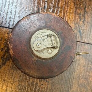 Mecoy Co. "Axiom" Vintage measuring tape housed in a leather-covered case.